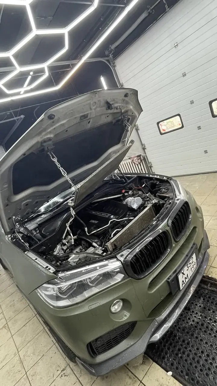 BMW с открытым капотом в рабочей зоне
